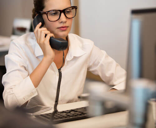 A woman in an office speaking on the phone