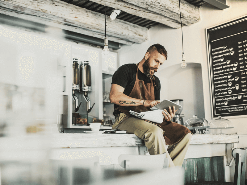 A coffee shop employee is working on taking care of the small business