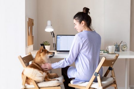A woman petting her dog while working from home