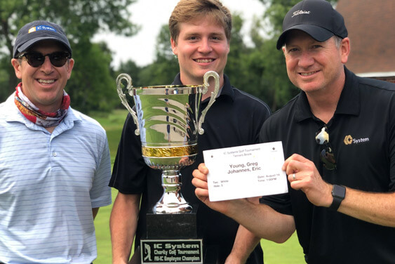 Golfers holding up their trophy and certificate at the IC Systems Annual Charity Golf Tournament